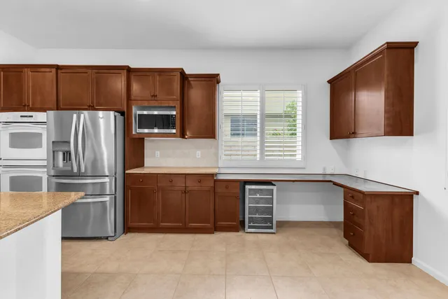 a kitchen with granite countertop a refrigerator and a stove top oven