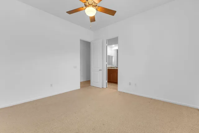 a bathroom with a granite countertop double vanity sink a mirror and a toilet