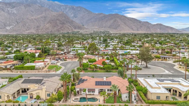 an aerial view of residential houses with outdoor space and mountain view