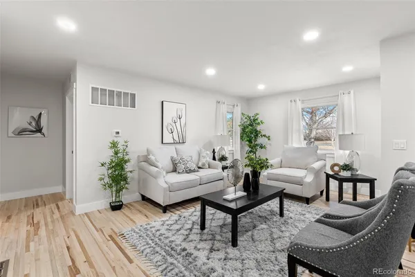 a living room with furniture and wooden floor