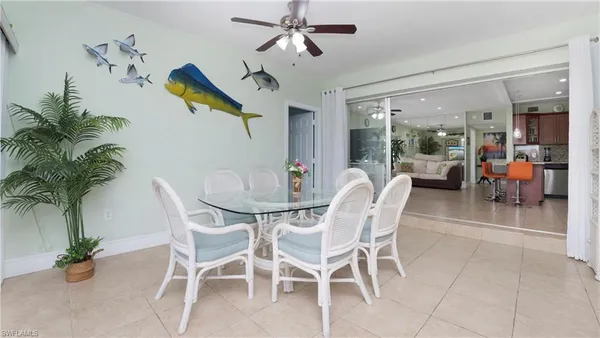 a dining room with furniture and a chandelier fan