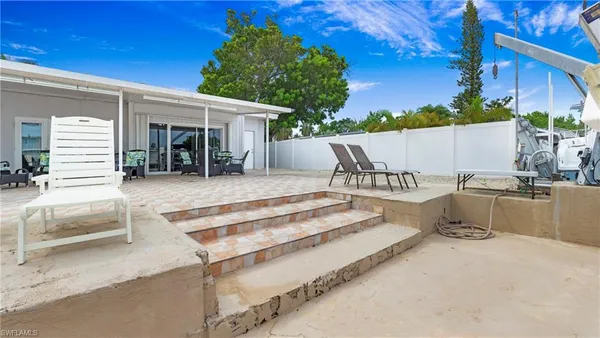 a view of a patio with table and chairs with wooden floor and fence