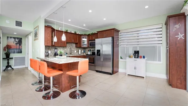a kitchen with stainless steel appliances kitchen island granite countertop a sink and cabinets
