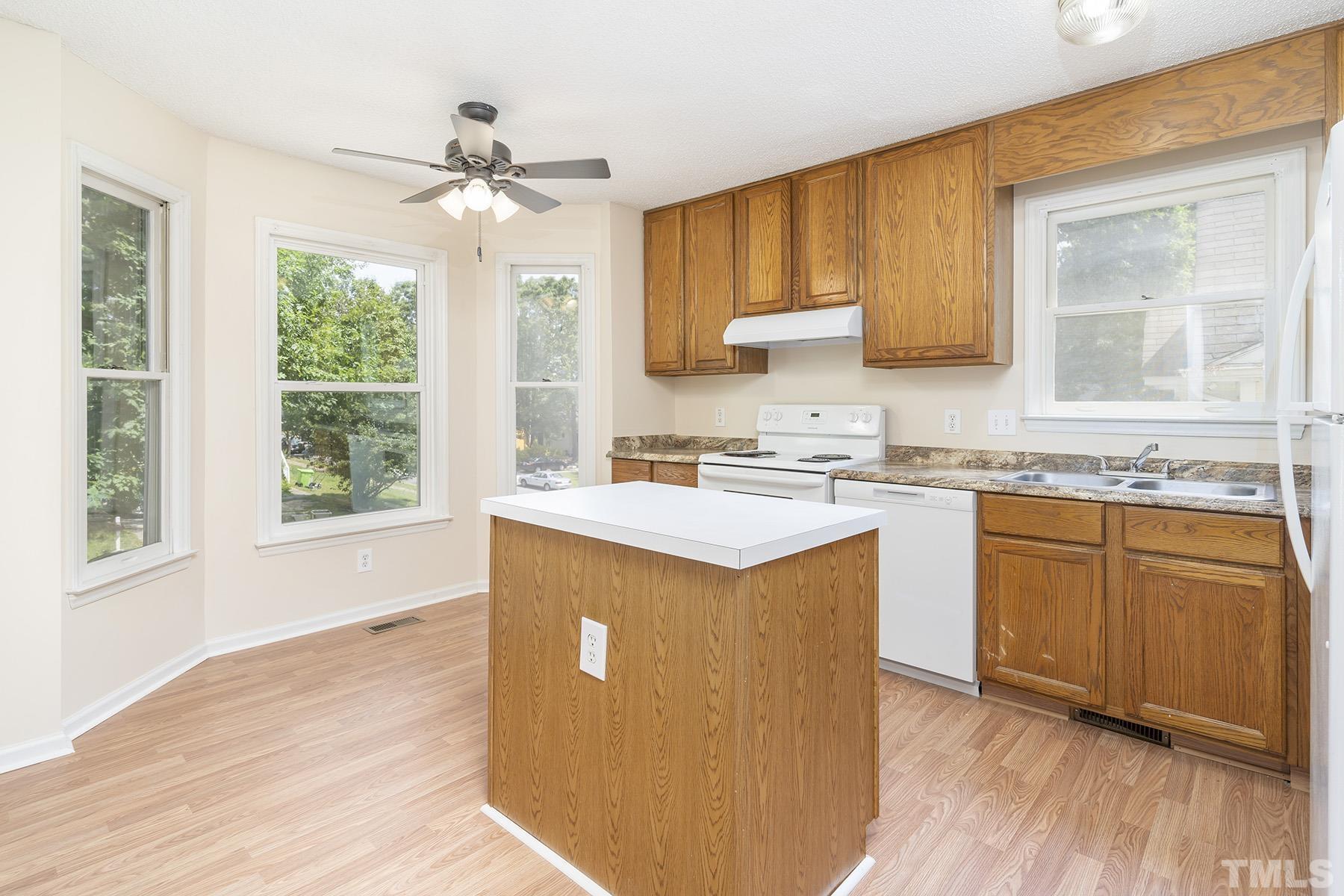 4105 Old Coach Road Raleigh, NC 27616 - Photo 4 of 22 a kitchen with granite countertop wooden floors and wide window