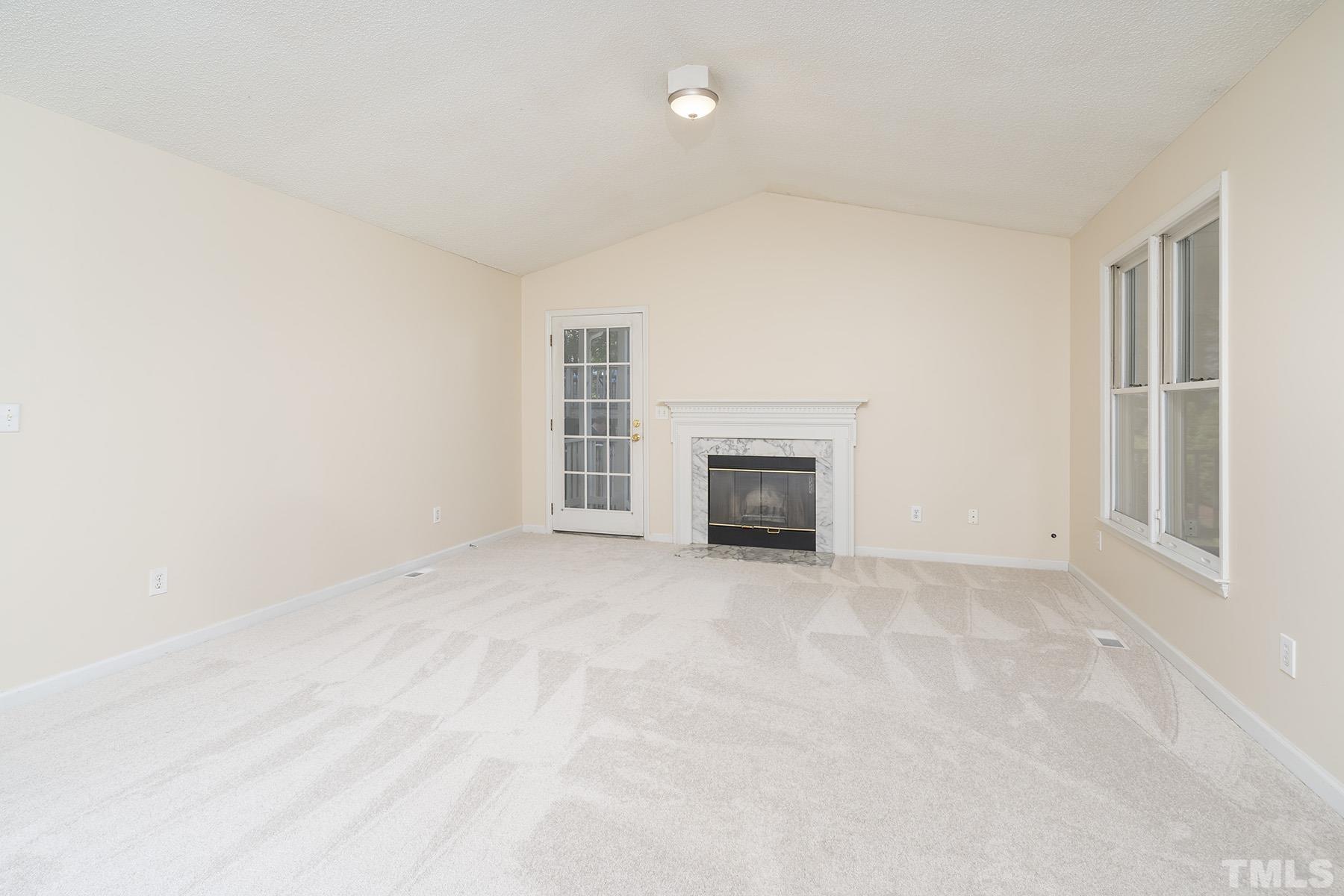 4105 Old Coach Road Raleigh, NC 27616 - Photo 6 of 22 an empty room with a fireplace and window