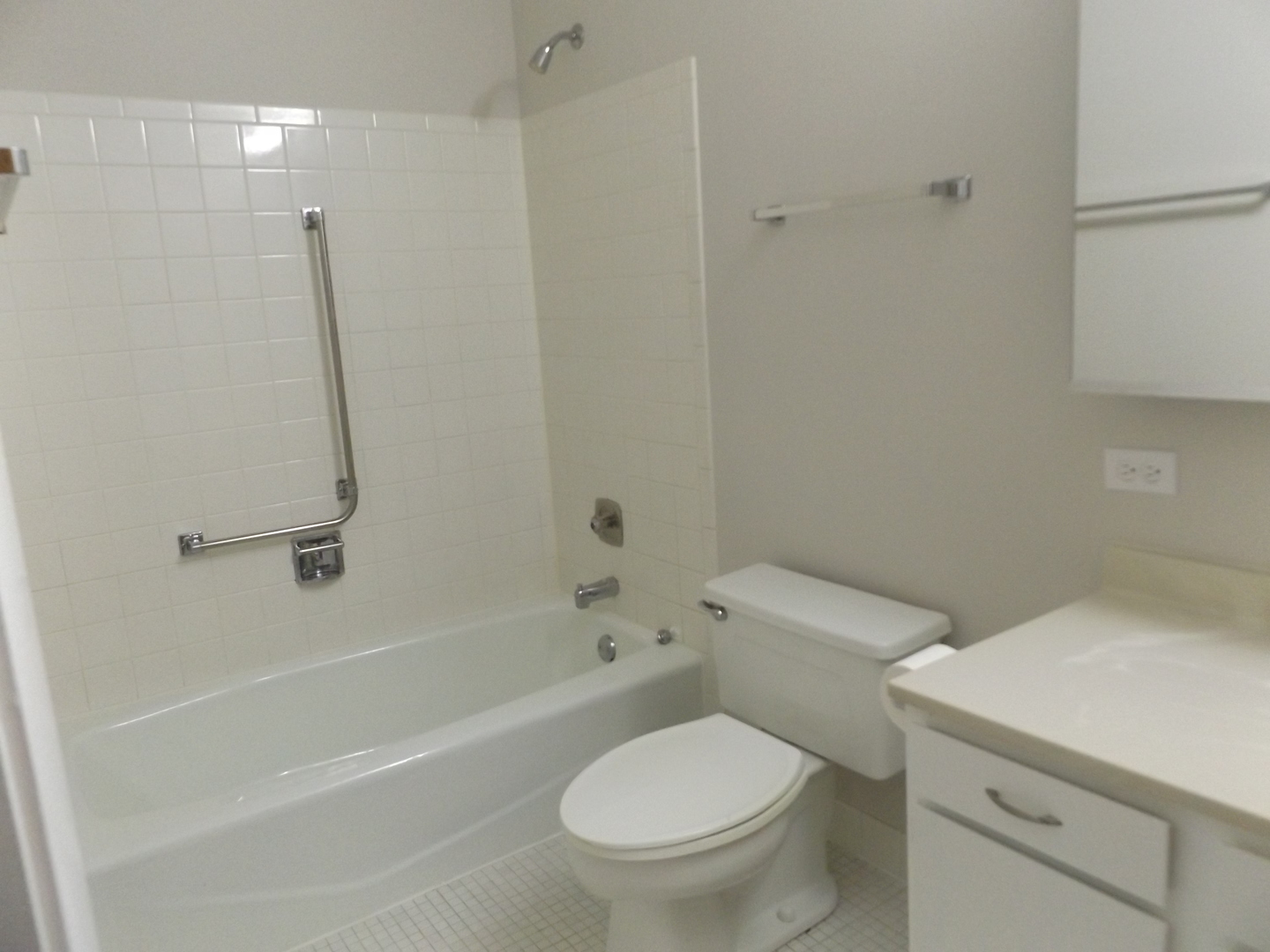 613 West Central Road, Unit C1 Mount Prospect, IL 60056 - Photo 11 of 14 a white toilet and tub sitting next to a bathroom sink