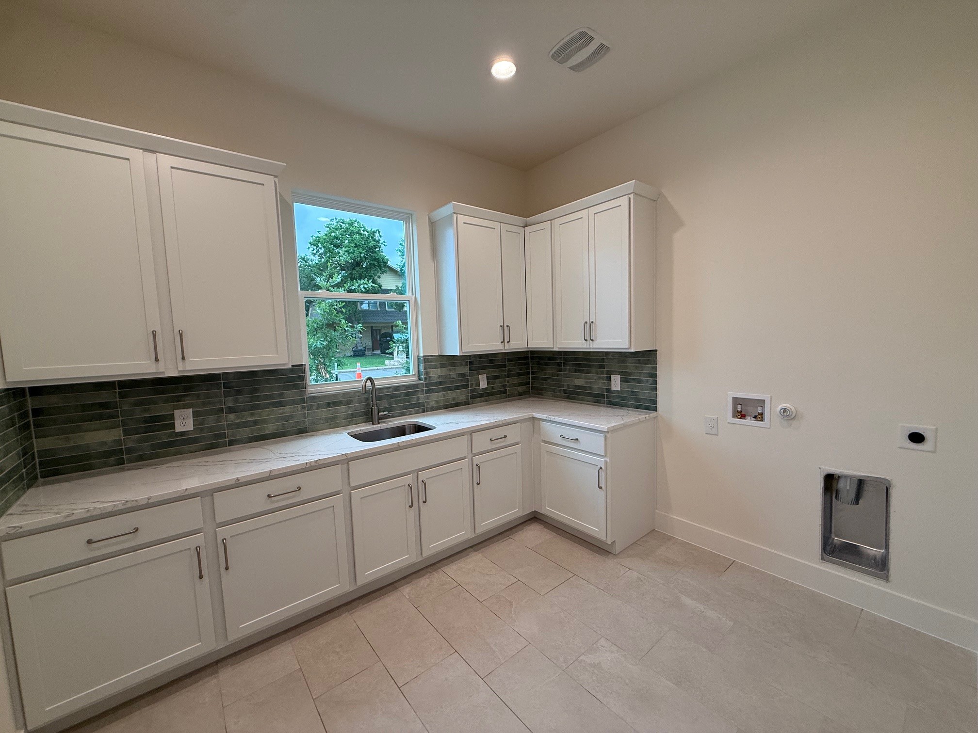 110 Firestone Place Meadowlakes, TX 78654 - Photo 16 of 18 Utility room with white cabinetry, a stainless steel sink, and a multi-toned tile backsplash