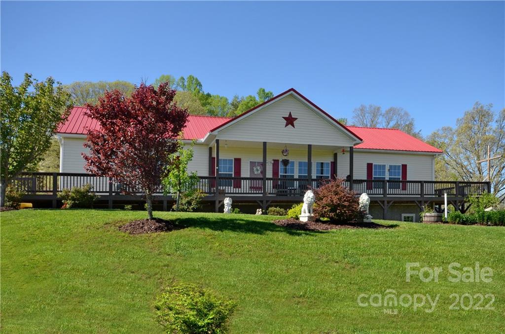 150 Triple R Drive Canton, NC 28716 - Photo 11 of 44 a front view of a house with a garden and trees