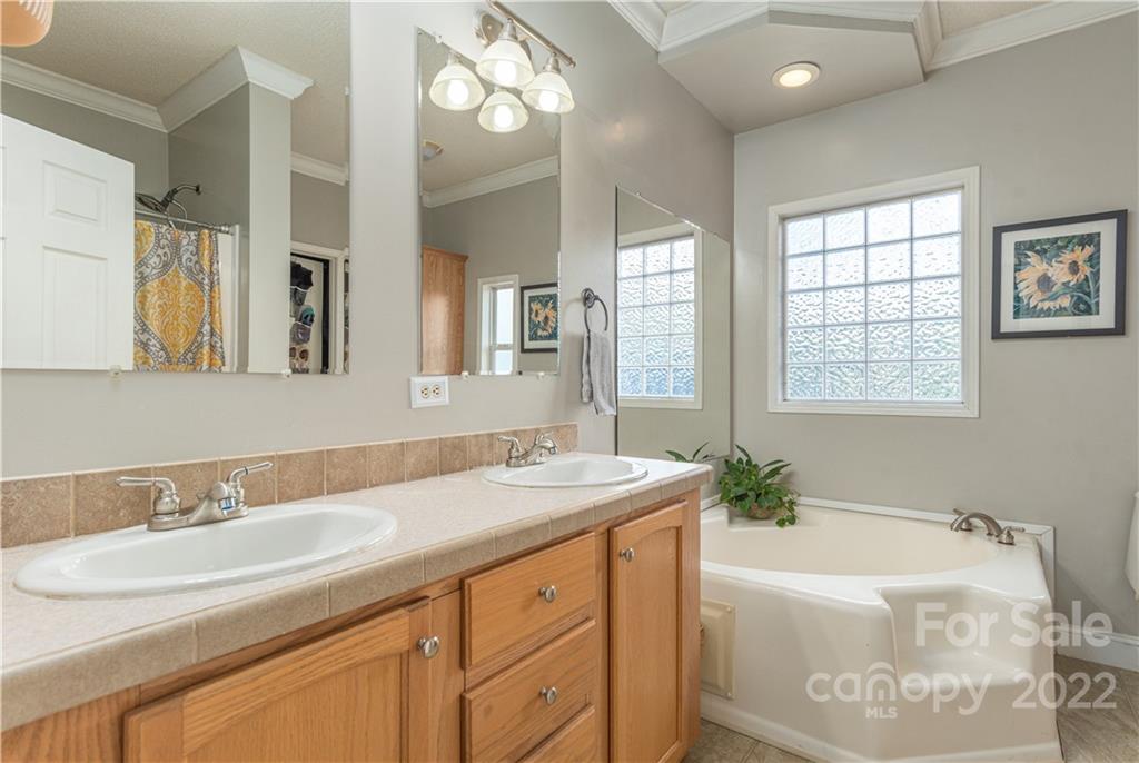 150 Triple R Drive Canton, NC 28716 - Photo 19 of 44 a bathroom with a granite countertop sink mirror and a bathtub
