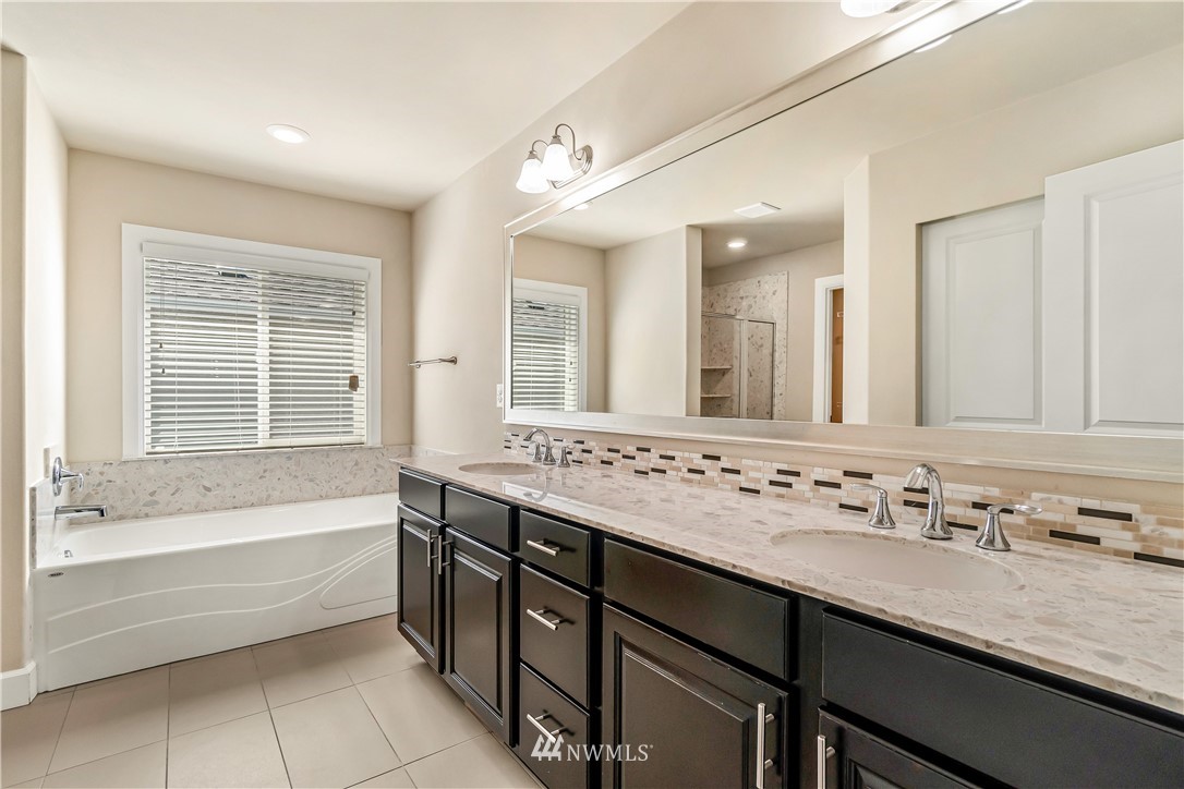 3917 174th Place Southeast Bothell, WA 98012 - Photo 19 of 31 a bathroom with a tub sink double vanity granite and a bathtub