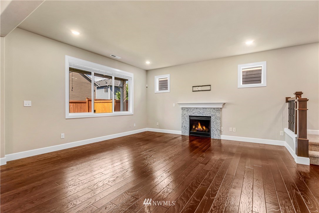 3917 174th Place Southeast Bothell, WA 98012 - Photo 4 of 31 a view of an empty room with wooden floor fireplace and a window
