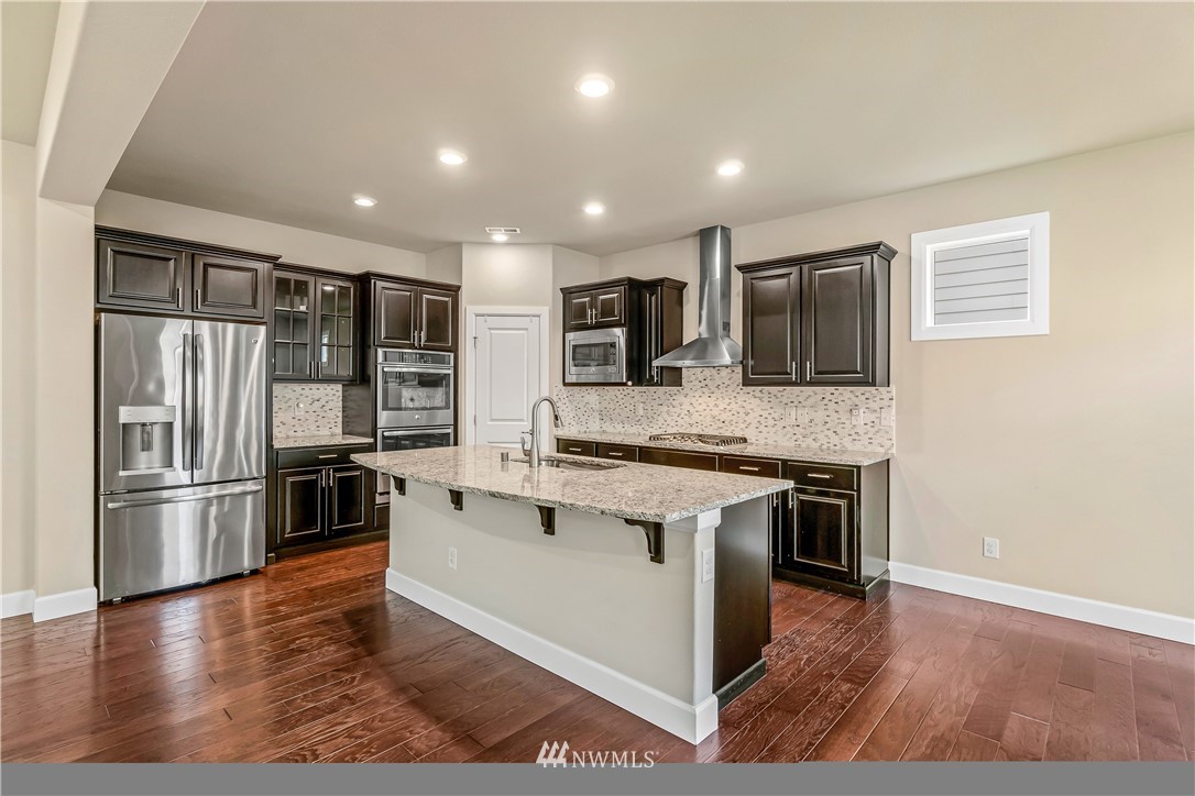3917 174th Place Southeast Bothell, WA 98012 - Photo 8 of 31 a kitchen with stainless steel appliances granite countertop a stove and a refrigerator