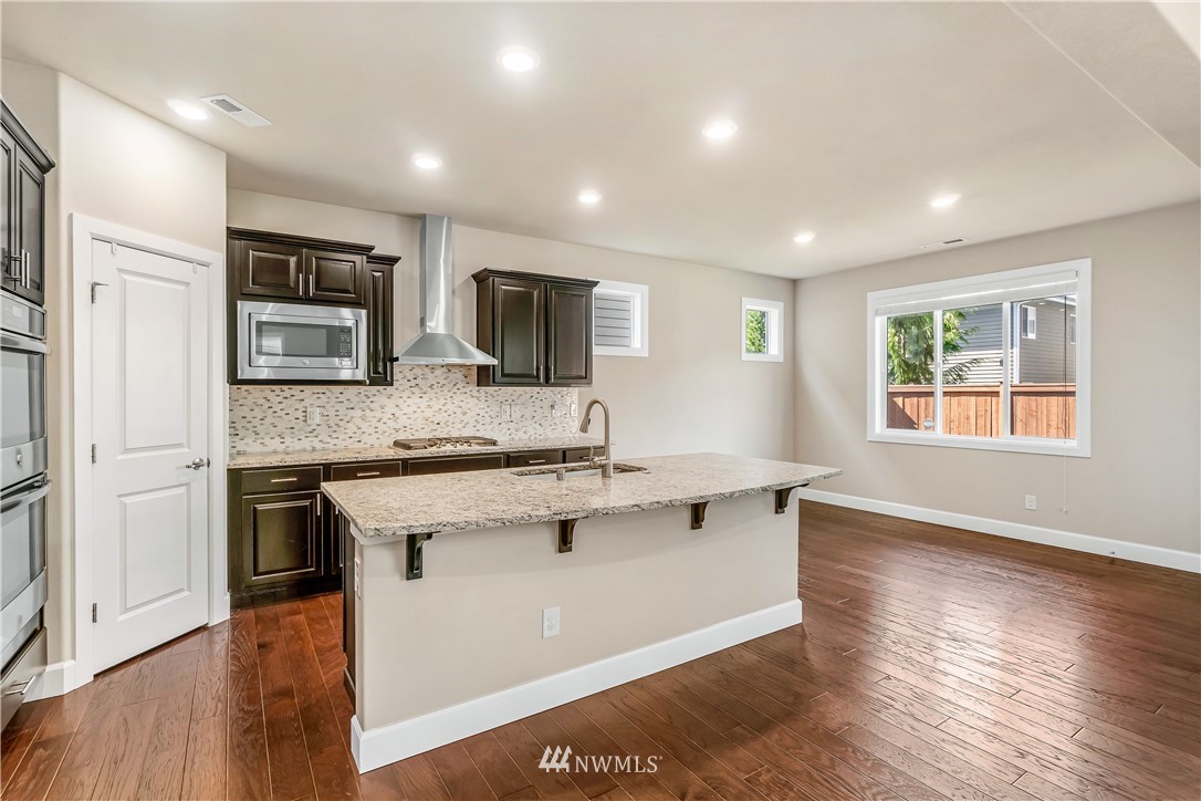 3917 174th Place Southeast Bothell, WA 98012 - Photo 9 of 31 a kitchen with stainless steel appliances granite countertop a stove top oven a sink dishwasher a refrigerator and a microwave