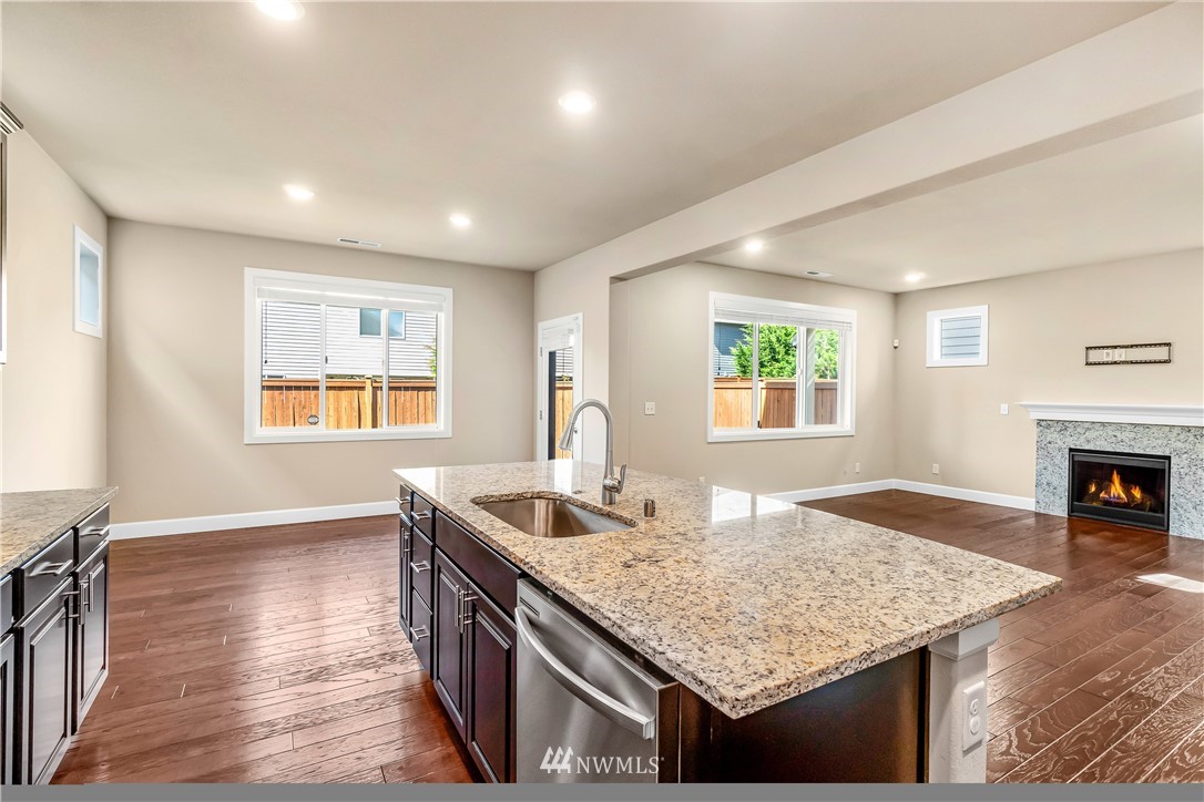 3917 174th Place Southeast Bothell, WA 98012 - Photo 10 of 31 a kitchen with granite countertop kitchen island sink stove and wooden floor