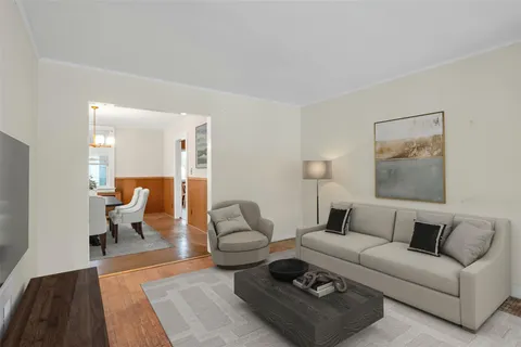 a living room with furniture a rug and a lamp