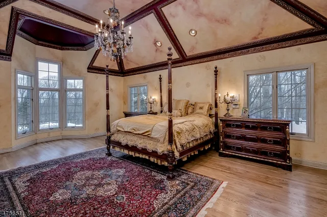 a bedroom with a bed a chandelier and a window