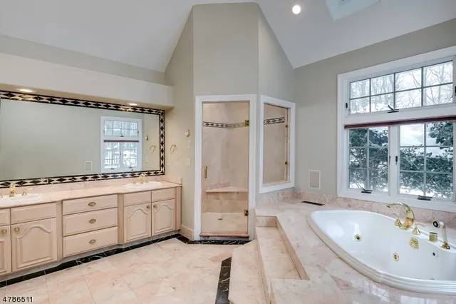 a bathroom with a tub sink shower and mirror