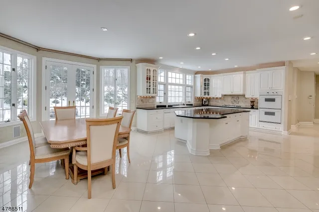a kitchen with stainless steel appliances granite countertop a stove a sink a microwave a dining table and chairs