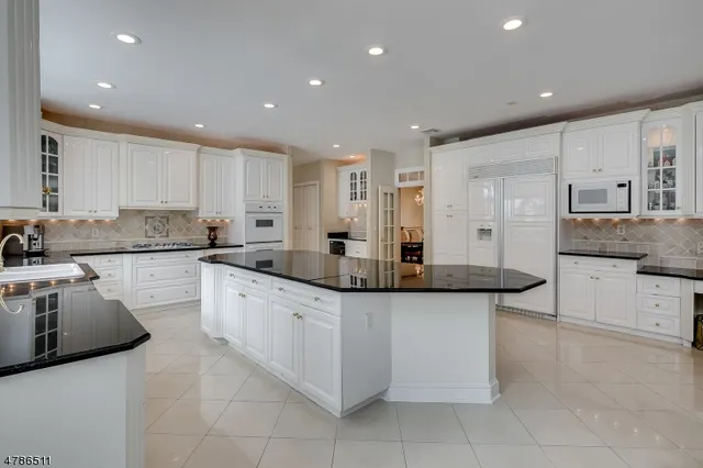 a kitchen with stainless steel appliances granite countertop a sink and white cabinets