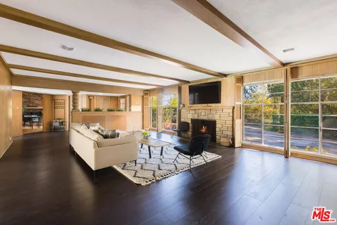a living room with fireplace furniture and a wooden floor