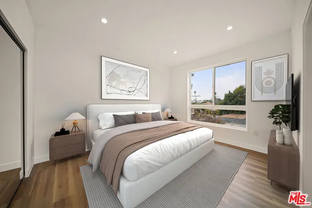 a spacious bedroom with a bed and a large window