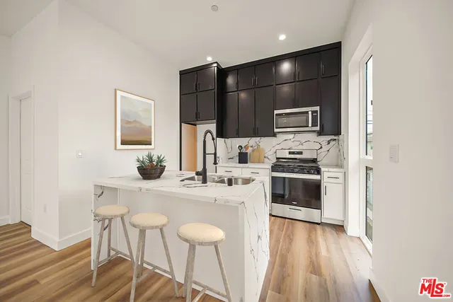 a kitchen with a sink a kitchen island and stainless steel appliances