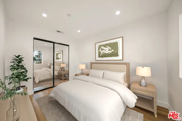 a bedroom with a large bed and a potted plant