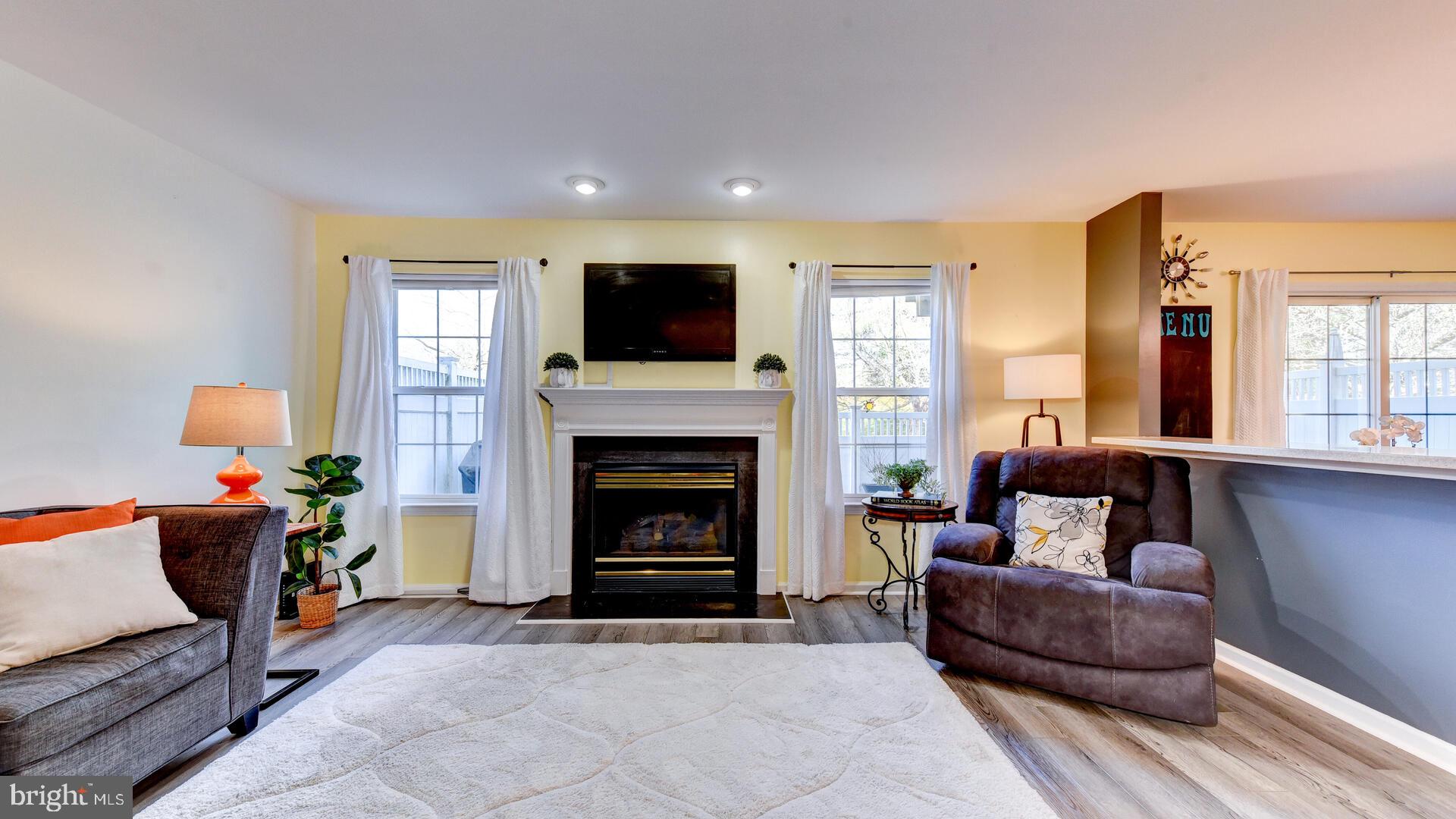 104 Coburn Road Pennington, NJ 08534 - Photo 12 of 40 a living room with furniture a flat screen tv and a fireplace