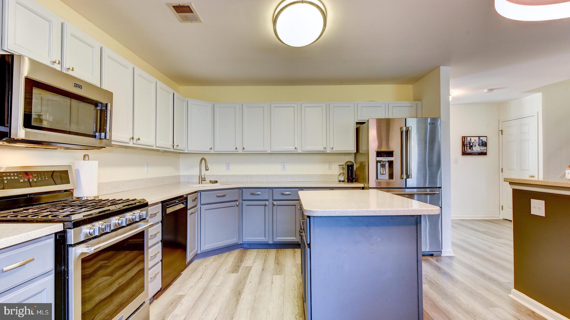 104 Coburn Road Pennington, NJ 08534 - Photo 17 of 40 a kitchen with stainless steel appliances granite countertop a stove top oven a sink dishwasher and white cabinets with wooden floor