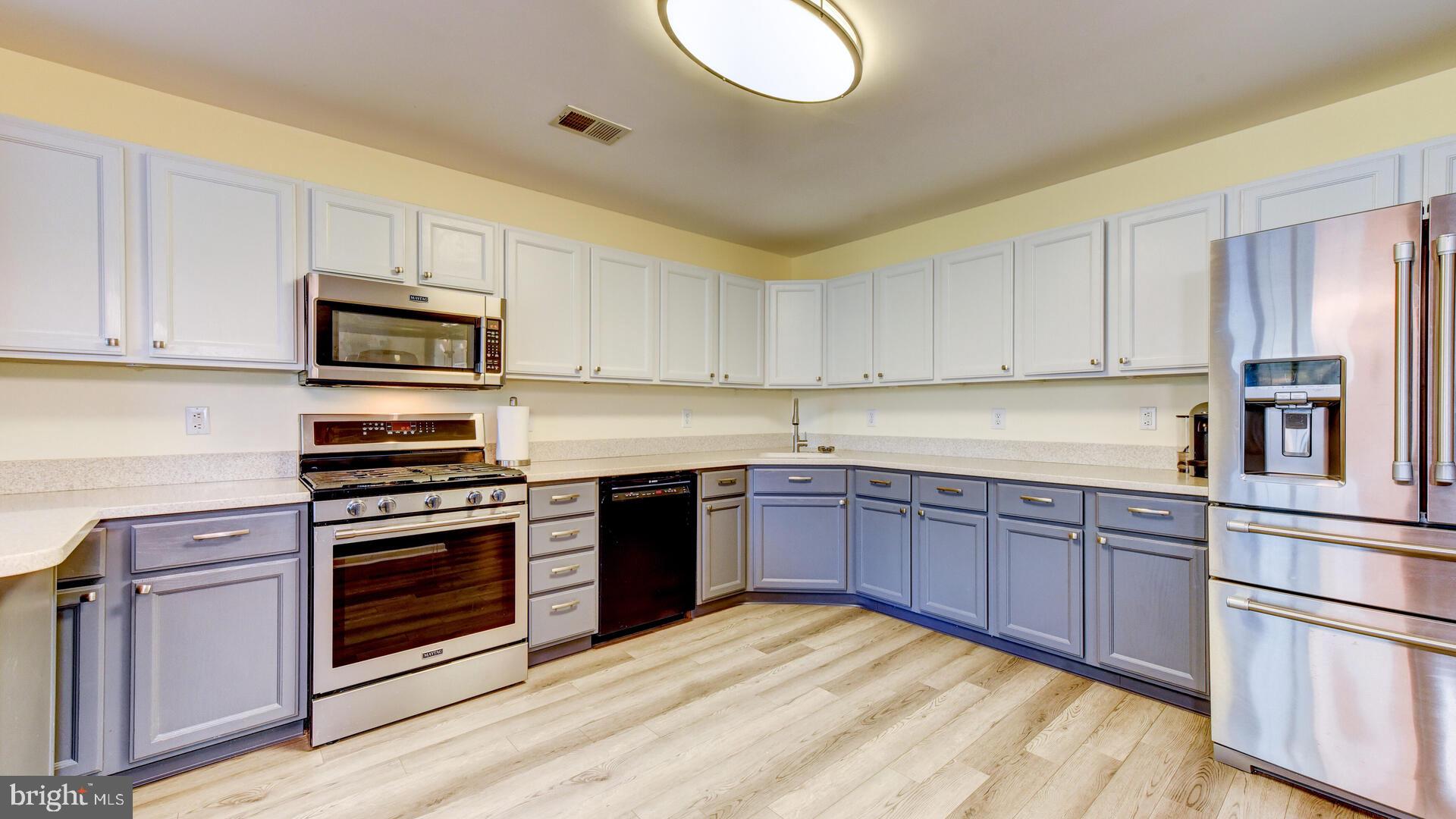 104 Coburn Road Pennington, NJ 08534 - Photo 20 of 40 a kitchen with stainless steel appliances granite countertop a stove top oven a sink dishwasher and a refrigerator with wooden cabinets