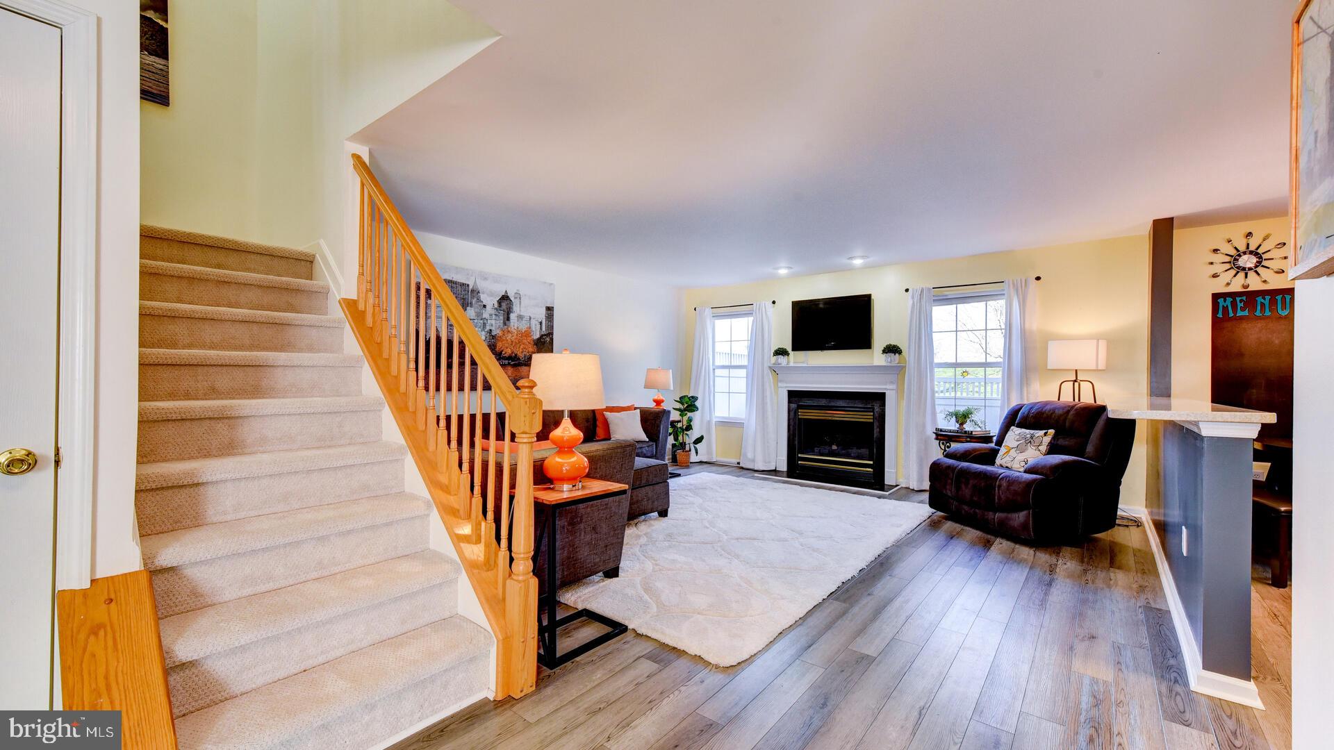 104 Coburn Road Pennington, NJ 08534 - Photo 8 of 40 a living room with furniture a flat screen tv and a fireplace