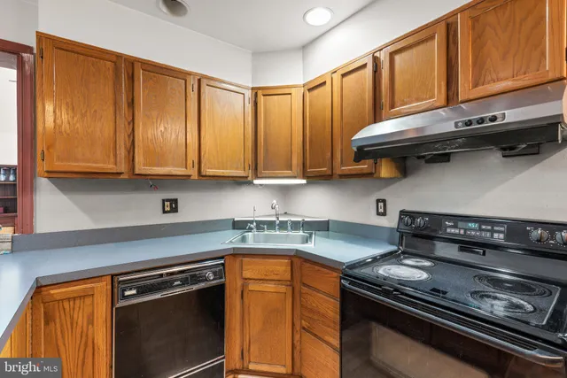a kitchen with stainless steel appliances granite countertop a stove a sink and cabinets