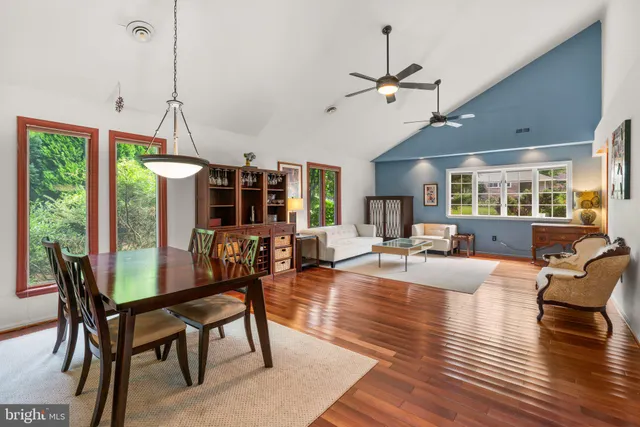 a view of a dining room and livingroom with furniture wooden floor a chandelier