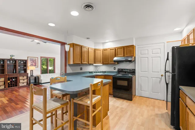 a kitchen with stainless steel appliances granite countertop a stove refrigerator sink and cabinets