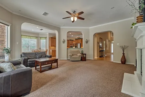 a living room with furniture and a large window with a chandelier