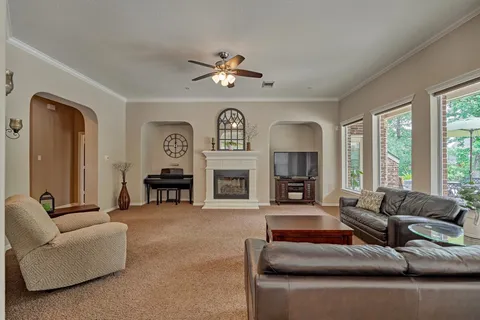 a living room with furniture a fireplace and a large window