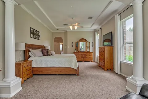 a spacious bedroom with a bed couch and a dresser