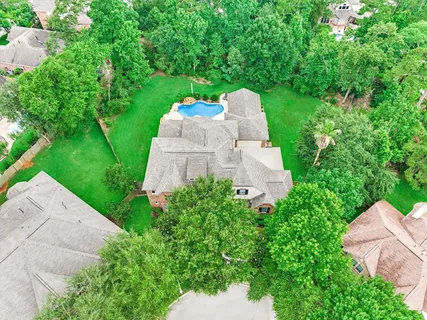 an aerial view of a house with a yard and tree s