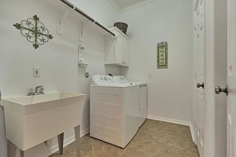 a utility room with cabinets washer and dryer