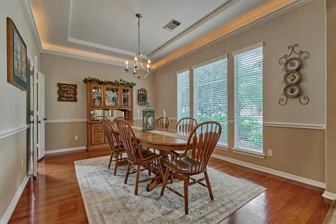 a dining room with furniture a chandelier and wooden floor