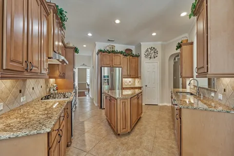 a kitchen with stainless steel appliances granite countertop a sink and a refrigerator