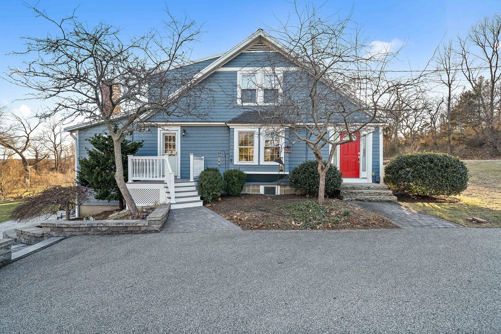 a view of a house with a yard and large tree