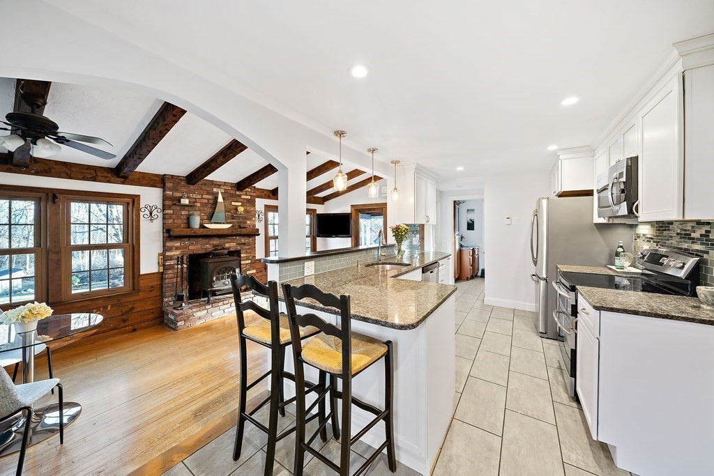 125 Driftway Scituate, MA 02066 - Photo 3 of 35 a kitchen with stainless steel appliances kitchen island granite countertop a table chairs sink and cabinets