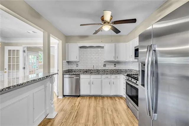 a kitchen with stainless steel appliances granite countertop a stove and a refrigerator