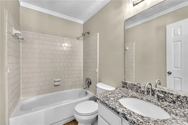 a bathroom with a granite countertop sink toilet mirror and shower