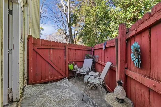 a backyard of a house with chairs and wooden fence