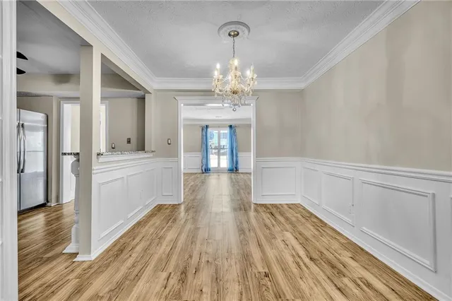 a view of a hallway with wooden floor and a kitchen