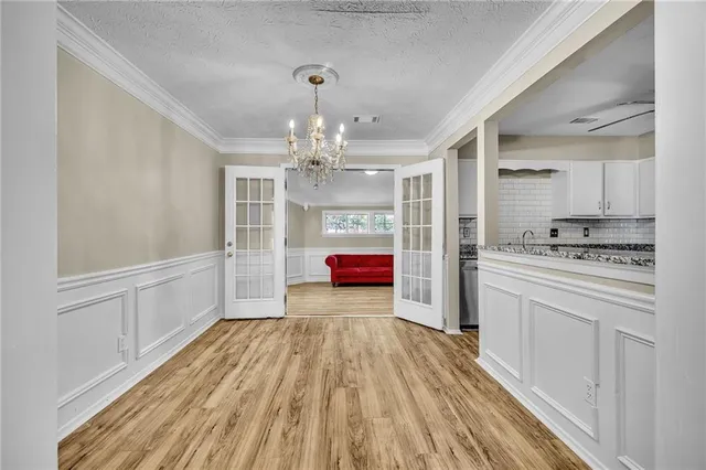 a kitchen with granite countertop a refrigerator and white cabinets