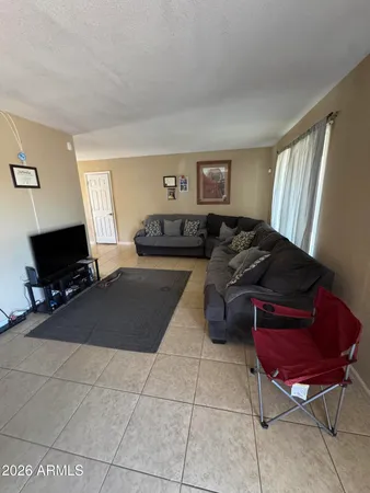 a living room with furniture a flat screen tv and a window