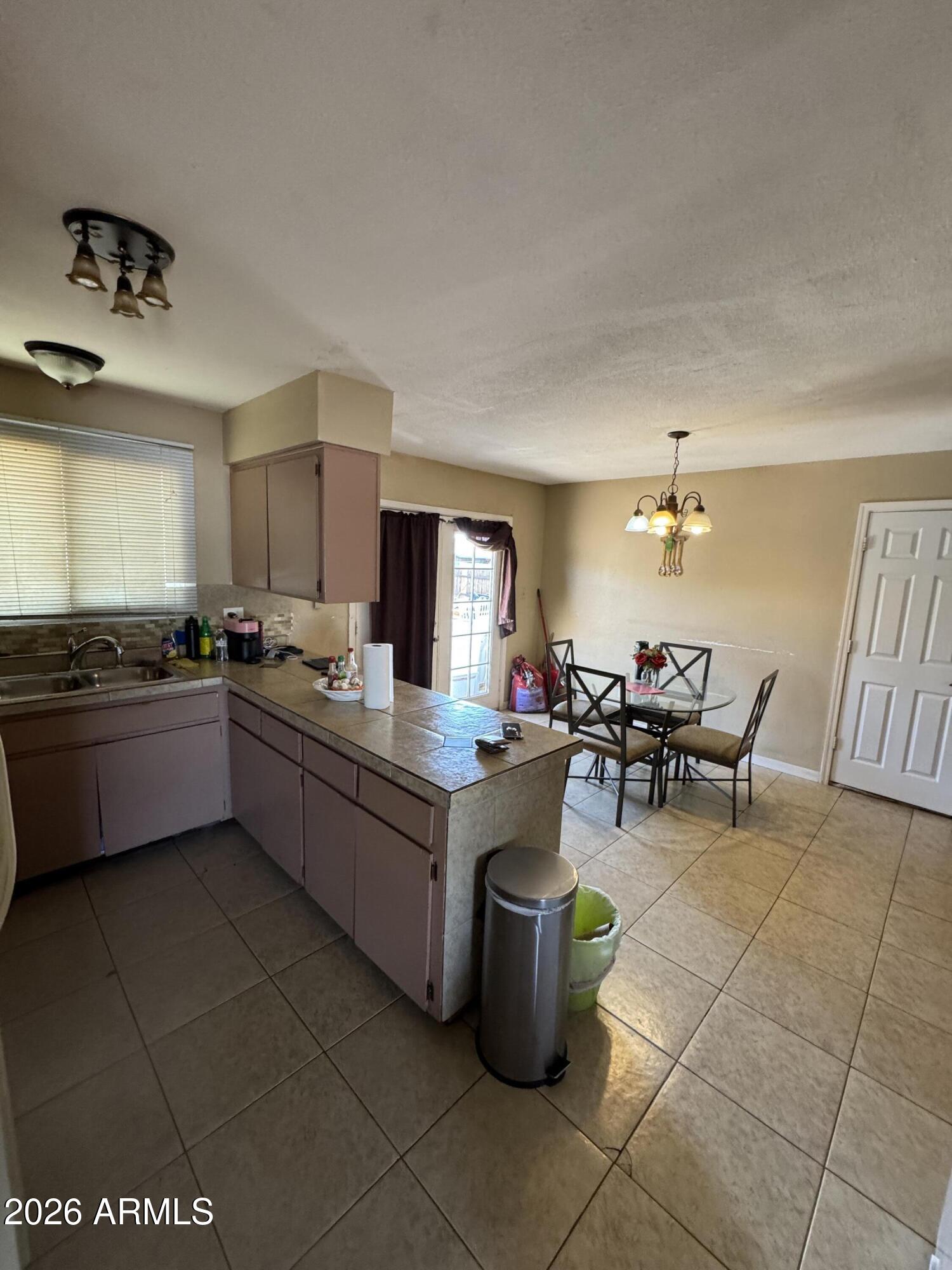 6313 West Osborn Road Phoenix, AZ 85033 - Photo 4 of 12 a kitchen with stainless steel appliances kitchen island granite countertop a sink and white cabinets